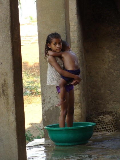 14- Jeune fille faisant la toilette à son petit frère.